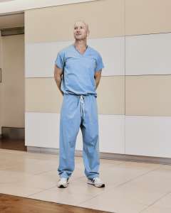 Dr. Jeffrey Veale in blue hospital scrubs and sneakers