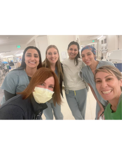 Group of healthcare professionals posing together in a hospital setting.