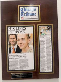 Framed Clinic Chronicle plaque showing article and portrait of two people. 
