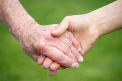 A young person and an older person holding hands