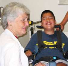 Margaret Jones with cerebral palsy patient who is smiling in his wheelchair