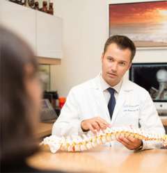 Luke Macyszyn, MD holding model of spine