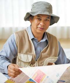 Man in fishing hat holding a map