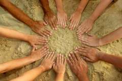 Hands in a circle on the sand