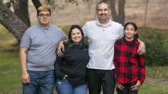 A smiling Lazaro Barajas with his family. From left to right: a teenage boy, a woman, a man, and a teenage girl.
