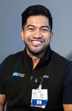 Michael Malig wearing a vest and ID badge, posed for a portrait.
