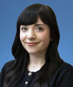 Headshot of Melissa Powell against a blue background.