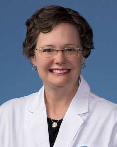Michelle Hickey, PhD, in a white lab coat