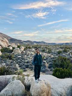 Dr. Husein outside on a rock