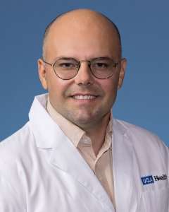 Imir Metushi, PhD in a white lab coat