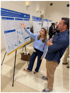 Woman pointing at research poster while explaining to an attentive man.