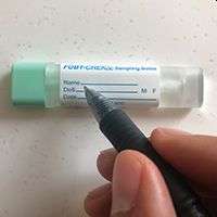 somebody drawing on a sample tube with a pen