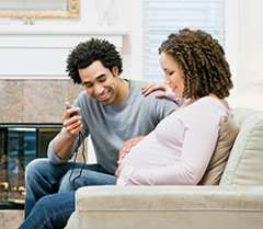 Pregnant woman sitting on couch with husband