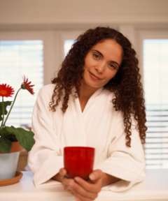 Woman in robe holding a cup