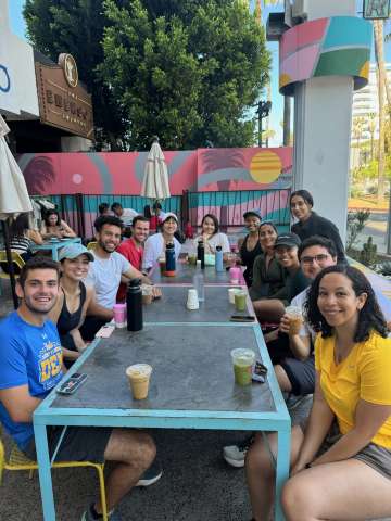 Internal Medicine Residents seated at a long table with coffees and teas