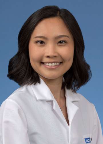 Head shot of Kristine Khieu in a white coat, smiling at camera