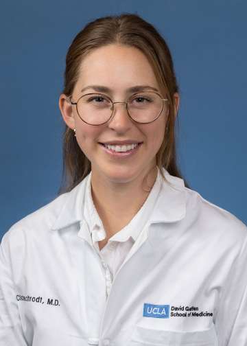 Head shot of Clare Schrodt in white lab coat, smiling at camera