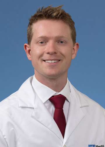 Dr. Sebastian Green in a white coat and tie smiling 