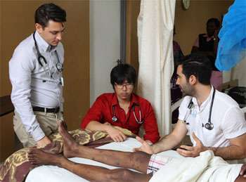Doctors treating patient in bed