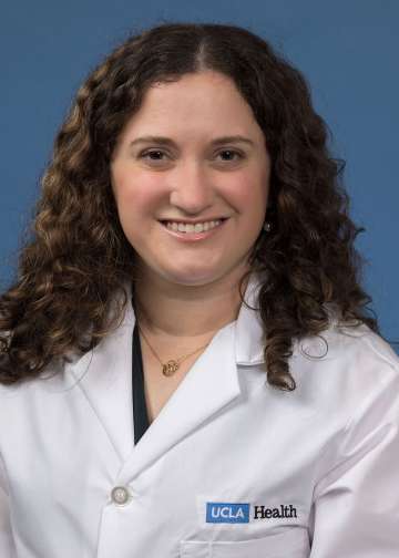 Head shot of Alexa Ciarolla in white lab coat, smiling at camera
