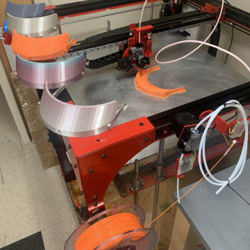 A 3D printer producing face shields.