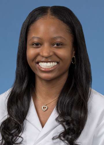 Head shot of Christina Ramsey in a white coat, smiling at camera