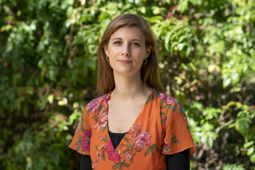 Ambre M. Bertholet wearing an orange dress with short sleeves and flowers.