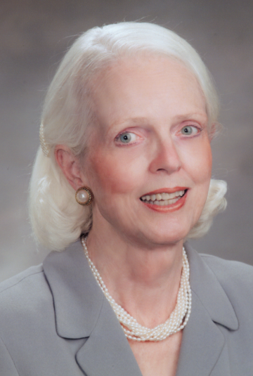 Selma Calmes, MD headshot, wearing a small pearls necklace and a gray suit jacket.