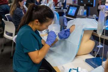 a hospitalists practicing needle injections on a prosthetic