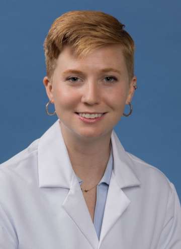 Head shot of Mallory Blackwood in white lab coat, smiling at camera