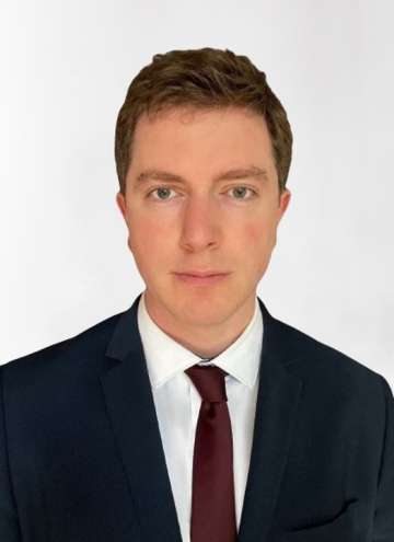 Head shot of Dylan Calame in business attire, looking at camera