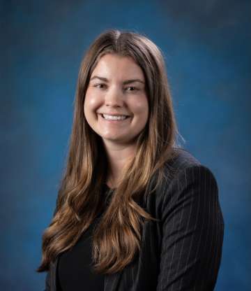 Head shot of Chloe Villars, MD in a dark top, smiling at camera
