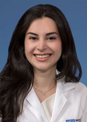 Head shot of Natalie Nabaty, MD in white coat, smiling at the camera