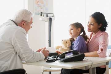 Doctor speaking to mother and daughter