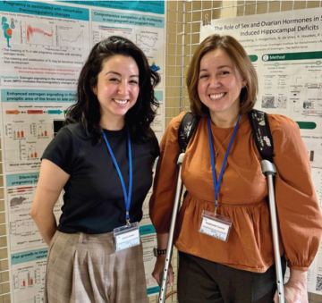 Laura Cortes, PhD, and their mentor posing in front of a research poster.