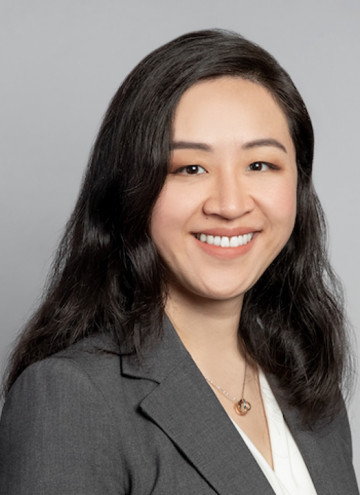Head shot of Irma Zhang in business attire, smiling at camera.