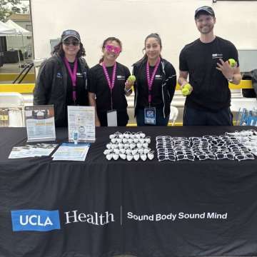 Four interns stand behind table with UCLA Health Sound Body Sound Mind