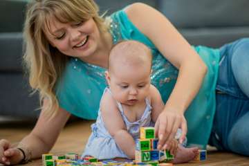 Mother and child playing with learning blocks on the floor