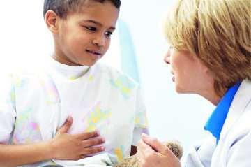 Child holding his stomach while speaking with a doctor
