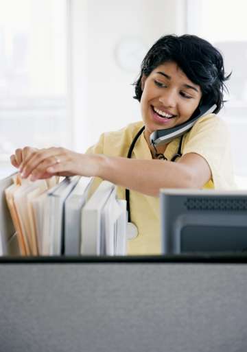 Nurse sifting through files while talking on the phone