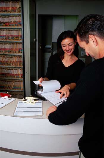 Two people in black shirts reading insurance forms