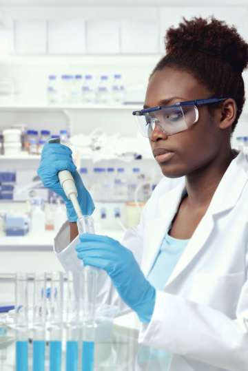 Researcher inserting liquid into vial with syringe