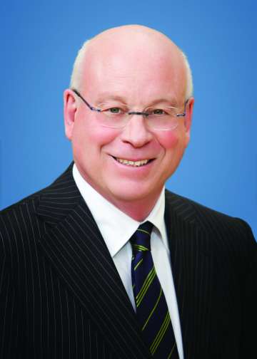 Dr. Michael Steinberg, wearing glasses and a dark striped suit, smiling in a professional headshot.