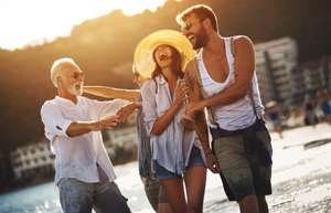 Three people walking on beach