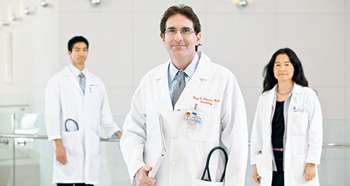 Three doctors standing next to each other in white lab coats