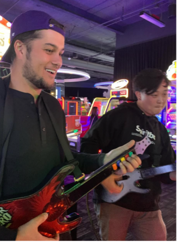 two Internal Medicine Residents in an arcade playing guitar hero