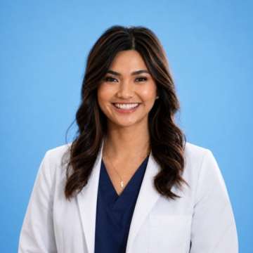 Jenica Martinssonprofessional in white coat and navy scrubs against solid blue background