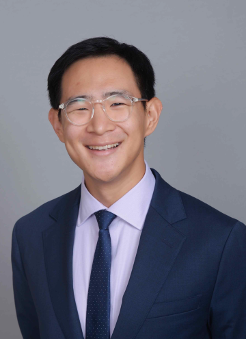 Head shot of Jerry Shen in business attire, smiling at camera