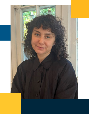 Monica is seated wearing a black button down shirt with a soft smile