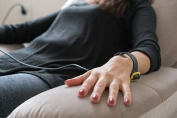 Woman sitting on couch checking biofeedback